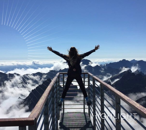 Femme debout sur un ponton face à la montagne. Sentiment de liberté et empowerment.