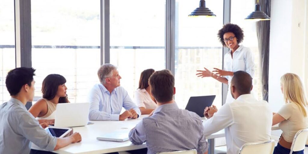 Femme debout qui parle devant ses collaborateurs lors d'une réunion