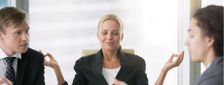 Femme qui médite au travail et qui reste calme au milieu d'une discussion tendue